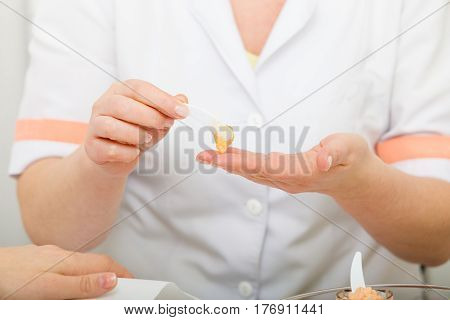 Handcare taking care of hands cosmetics concept. Woman applying cream on hand using spatula