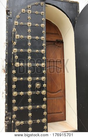 Ancient solid double doors open decorated gold flowers