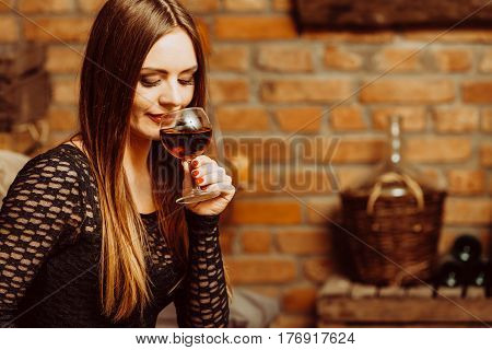 Elegant beauty lady long hair full make up wearing black dress tasting wine in rural cottage interior celler