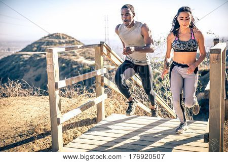 Couple running in los angeles canyons. making exercises after run