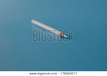 white pancil isolated on a blue background