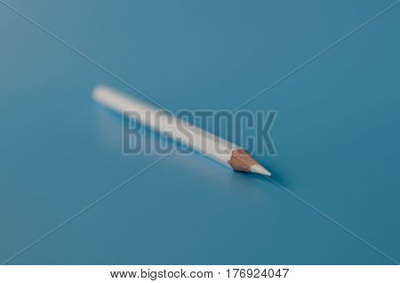 white pancil isolated on a blue background