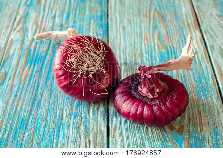 Red onions on a blue wooden table close up