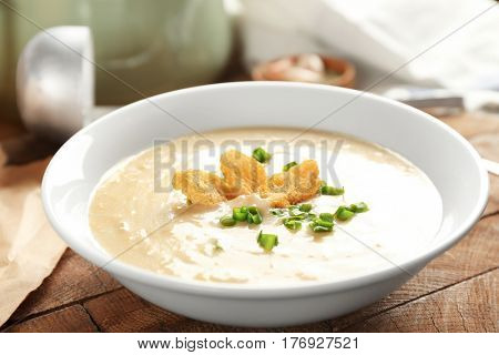 Delicious cream soup with bread on table