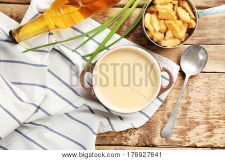 Delicious beer cheese soup with croutons on table