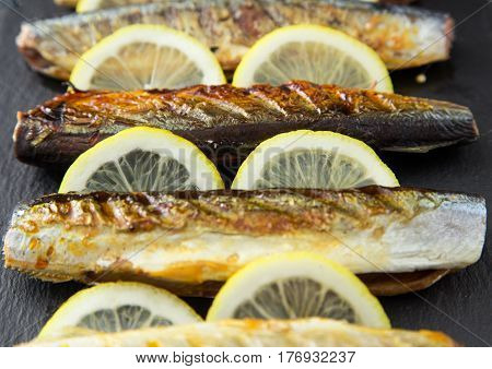 Grilled Fish Saury With Lemon On A Slate Board