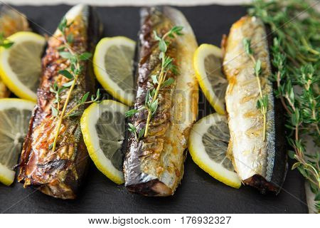 Grilled Fish Saury With Lemon On A Slate Board