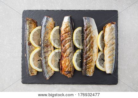 Grilled Fish Saury With Lemon On A Slate Board