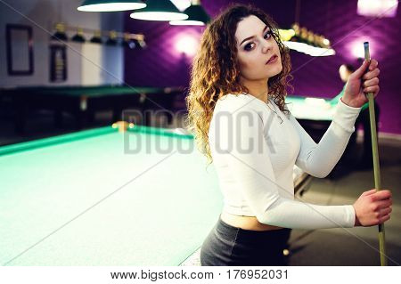 Young Curly Girl Posed Near Billiard Table. Sexy Model At Black Mini Mini Skirt Play Russian Snooker