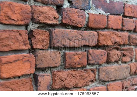 Fragment of old brick wall with multicolored bricks and tones background