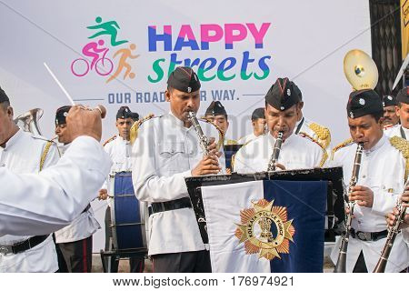 KOLKATA WEST BENGAL INDIA - FEBRUARY 7TH 2016 : Kolkata Police Force Officers dressed in white and black suits are playing band using various musical instruments in a winter morning.
