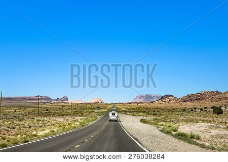 People Travel With Caravan To The Moument Valley Under Blue Sky