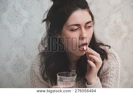 A Young Girl Wrapped In A Blanket And During Illness And Checks The Temperature Looking At The Therm
