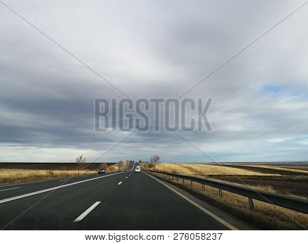 Couds On The Highway - Winter Time - People Traveling By Car In A Sunny Winter Day