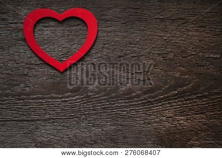 The Red Heart Is Located On An Old Wooden Brown Dry Board. Valentines Day Card