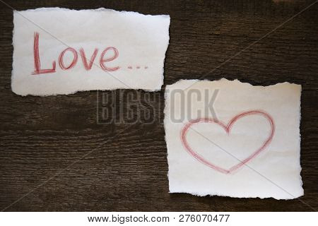 The Word Love Is Written In Red Pencil On A Piece Of Paper, The Heart Is Drawn In Red Pencil On A Pi