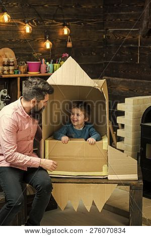 Kid Happy Sit In Cardboard Hand Made Rocket. Child Boy Play Cosmonaut, Astronaut. Parenthood Concept