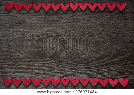 The Red Hearts Are Located Horizontally On The Upper And Lower Edges Of The Old Wooden Brown Dry Woo