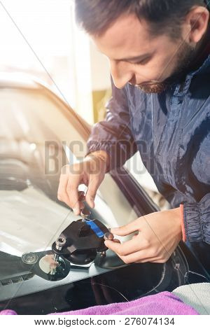 Close-up Of A Professional Windshield Repairman Working With Hydraulic Polymer Crack Filler. Elimina