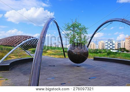 The Construction Of Metal Structures With A Metal Sphere Suspended From Them With A Tree Ficus Sycom