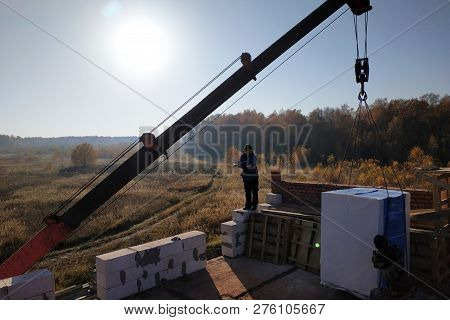 The Employee Controls The Unloading Of Blocks For The Construction Of A House At The Time Farm