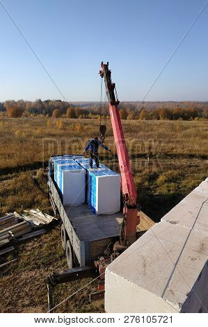 The Employee Controls The Unloading Of Blocks For The Construction Of A House At The Time Farm