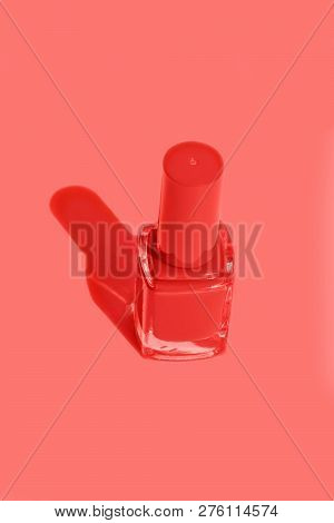 Bottle With Nail Polish Of Trendy Living Coral Color On Solid Monochrome Orangy-pink Background. Str