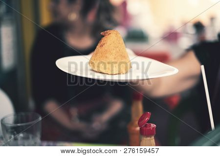 Person Holding A Plate With A Coxinha (brazilian Chicken Croquette) On It