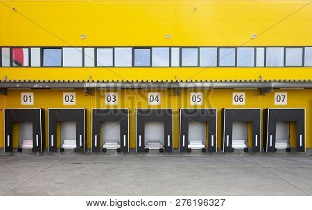 Seven Truck Loading Docks At A Distribution Warehouse. Distribution Hub For Sorting Packages And Par