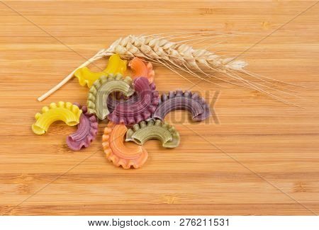 Several Uncooked Colored Short Curved And Ruffled Pasta Also Known As Creste Di Gallo Pasta And Ear 