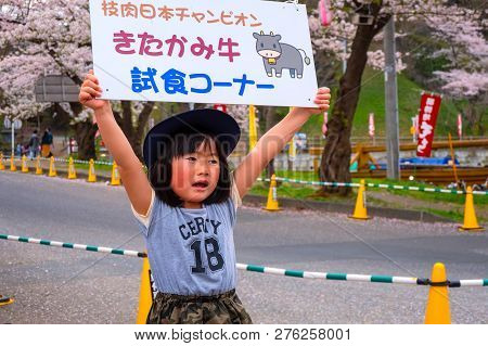 Iwate , Japan - April 22 2018: Unidentified Young Japanese Girl Holds Sign Selling The Kitakami Beef
