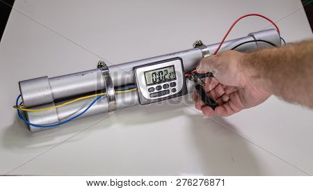 Hand Cutting Wire On Pipe Bomb On White Background
