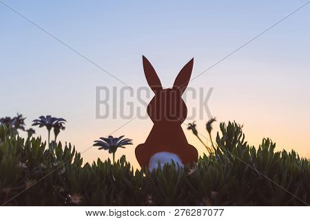 Creative Easter Photo Of Silhouette  Paper Rabbit In The Chamomile Flowers And Green Grass On The Su
