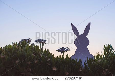 Creative Easter Photo Of Silhouette  Paper Rabbit In The Chamomile Flowers And Green Grass On The Su