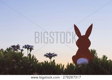Creative Easter Photo Of Silhouette  Paper Rabbit In The Chamomile Flowers And Green Grass On The Su