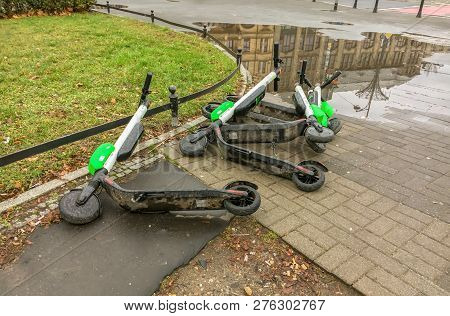 An Abandoned Dirty Lime Scooters Lie On The Ground Of A Street In Wroclaw, Poland.
