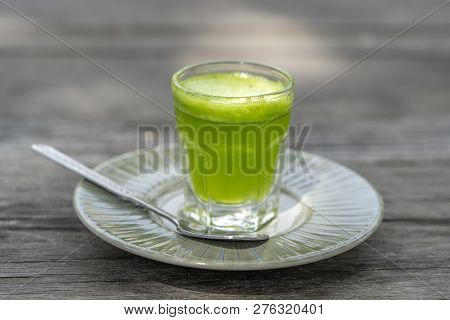 Wheat Grass Juice Natural Drink With Fresh Wheatgrass In Glass On Old Wooden Table Background. Organ