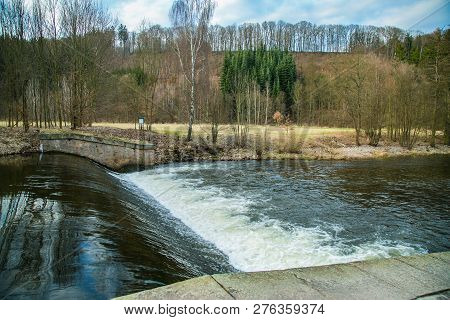 View Of Spring Nature Landscape And A Dangerous Weir At River Upa, Dark Water, White Riffles, The Cz