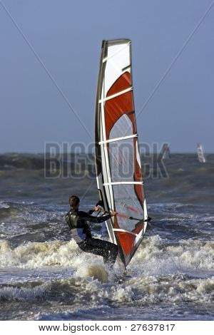 Surfař na pobřeží Severního moře v Nizozemsku