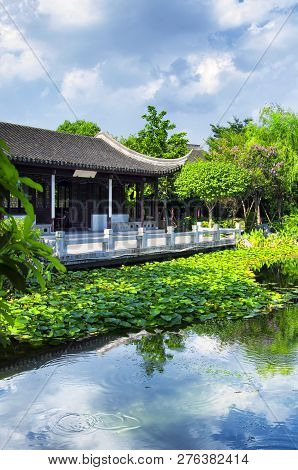 A Chinese Building On A Small Lake Within The Luzhi Ancient Town Scenic Area On A Sunny Day In Wuzho