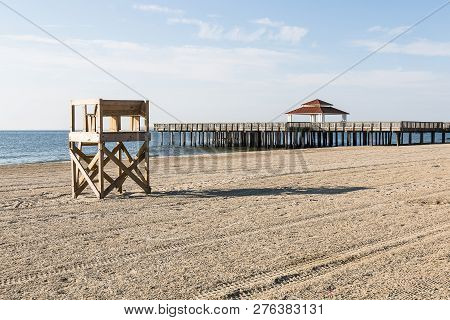Lifeguard Tower On An Empty Beach With The Public Viewing Pier At Buckroe Beach In Hampton, Virginia