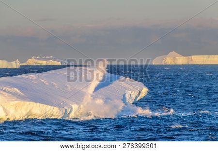 Antarctic Sunset: Water Spewing Out Of An  Iceberg Floating  In The Weddell Sea, Near The Antarctic 