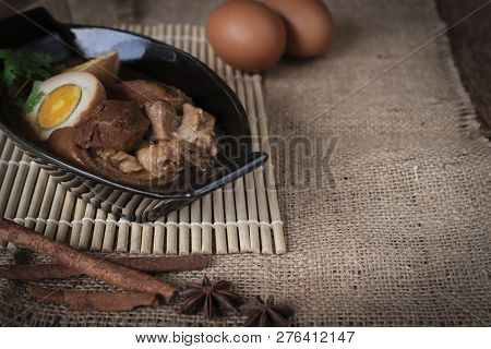 Stewed Eggs And Pork In Black Bowl And Spices Place In Front Of And Eggs Place Backside On Wood Siev