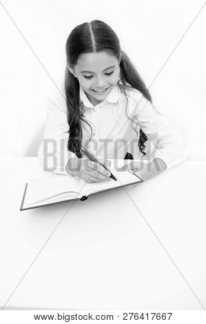 Little Bookworm. Writing Notices. Girl Child Writes Hometask While Sit Table White Background. Schoo