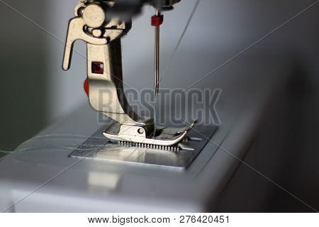 Close-up Photo Of A Sewing Machine. Pressing Foot, Double Needle, Light Blue Thread. Selectively Foc