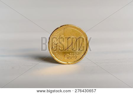 A 20 Cent Euro Coin Standing On A Wooden Background