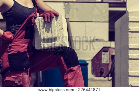 Unrecognizable Woman Working On Construction Site, Building House, Installing Gray Airbricks. Indust