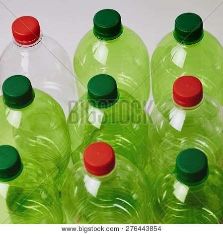 Many Green Plastic Bottles With Caps. Production Of Beverages In Plastic Containers. Problem Of Envi