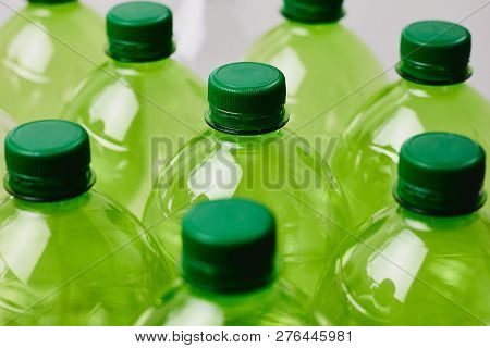 Many Green Plastic Bottles With Caps. Production Of Beverages In Plastic Containers. Problem Of Envi
