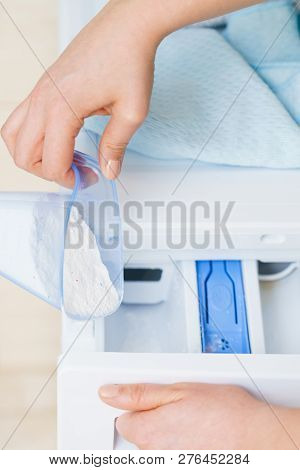 Washing Powder Detergent And Measuring Cup Pouring Into Machine. Household Duties, Clothes Laundry O